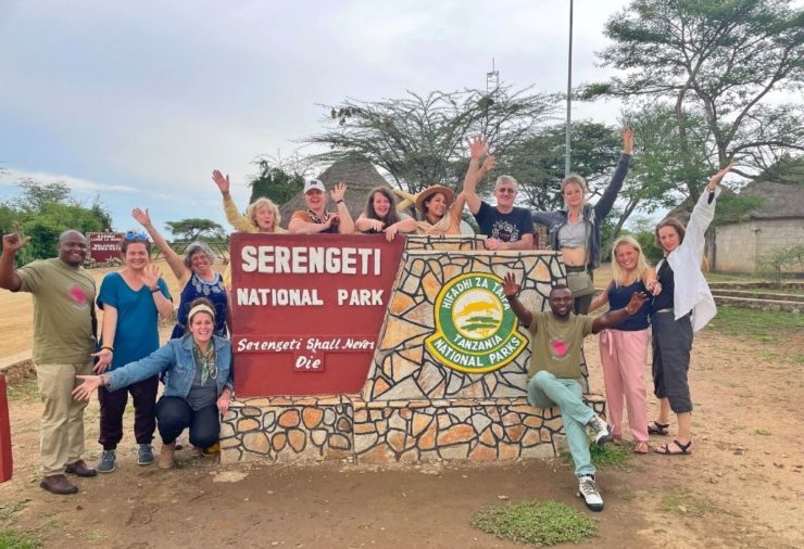 Group of people by the Serengeti sign in Tanzania