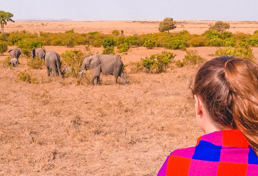 Girl watching elephants in the Maasai Mara